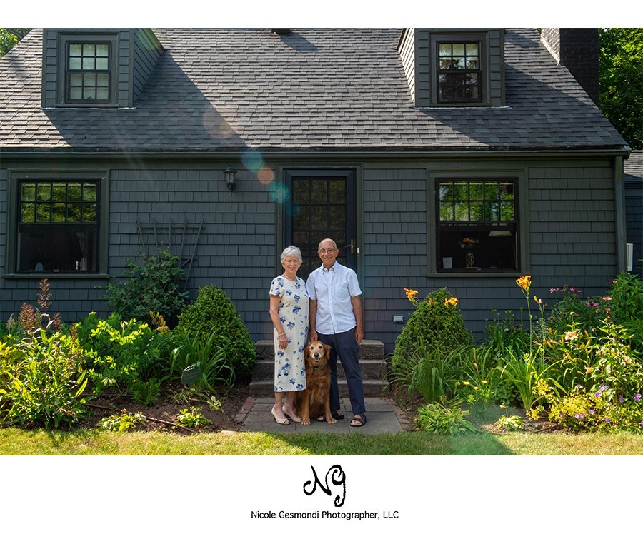 elderly husband and wife standing in front of their home in Barrington RI