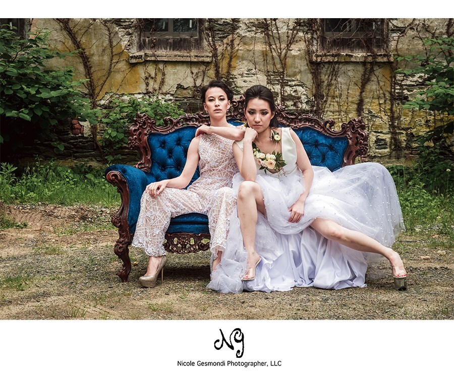Two brides on a vintage blue couch